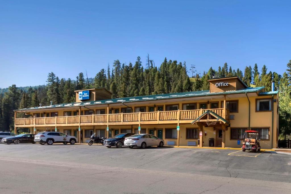 un grand hôtel avec des voitures garées dans un parking dans l'établissement Best Western Rivers Edge, à Red River