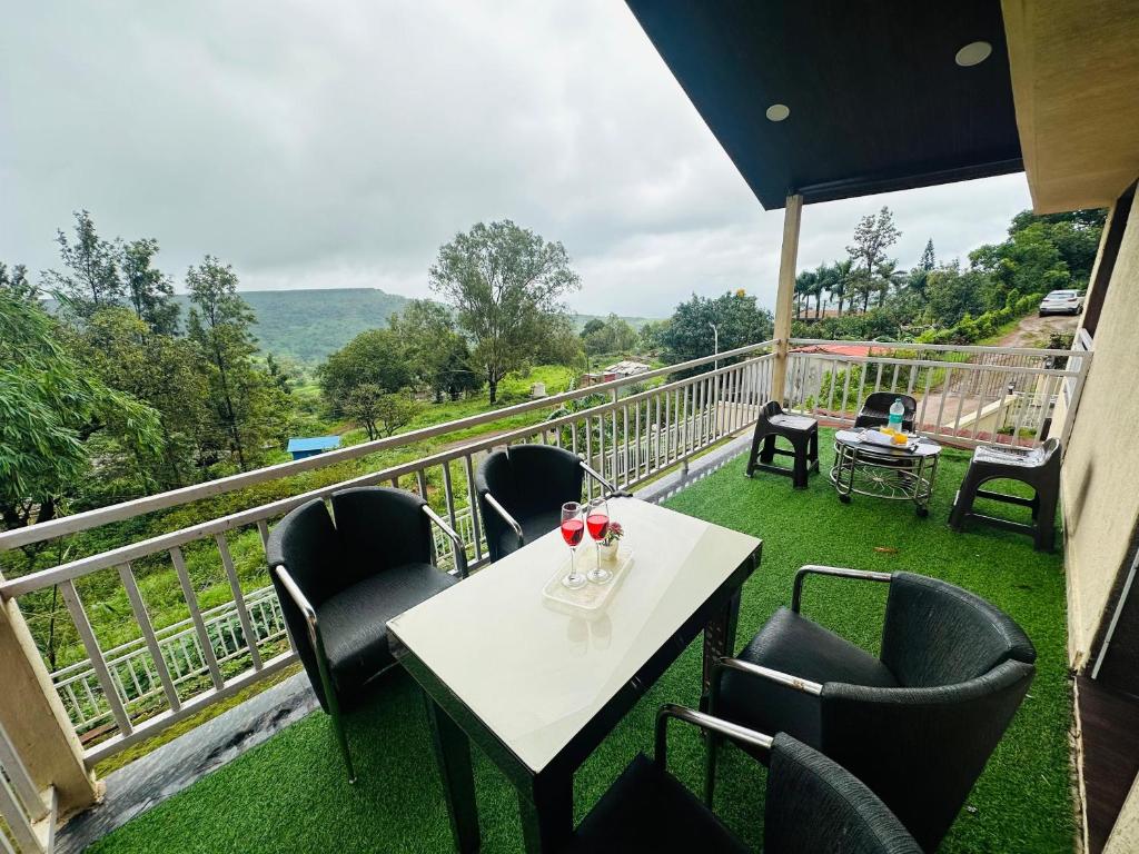 un tavolo e sedie su un balcone con vista di Lifeline Villas - Skyy High Luxurious Villa With Table Land & Valley View Villa a Panchgani