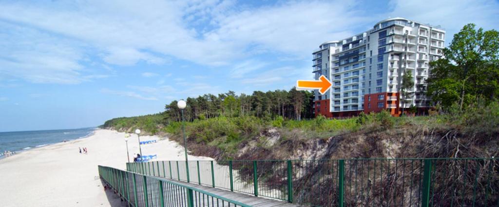 een gebouw aan het strand naast een zandstrand bij Apartament Superior de Lux - Porta Mare in Dziwnówek