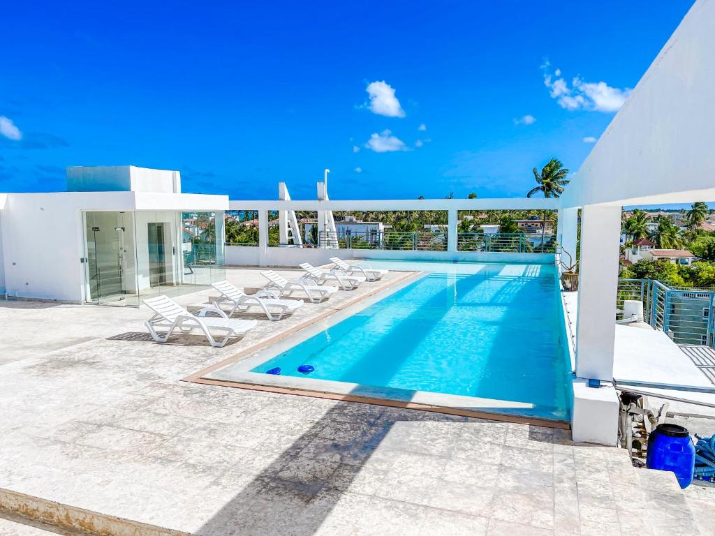 - une piscine sur le côté d'une maison dans l'établissement DUCASSI Suites ROOMS BEACH playa Bavaro WiFi Parking ROOFTOP POOL SPA, à Punta Cana