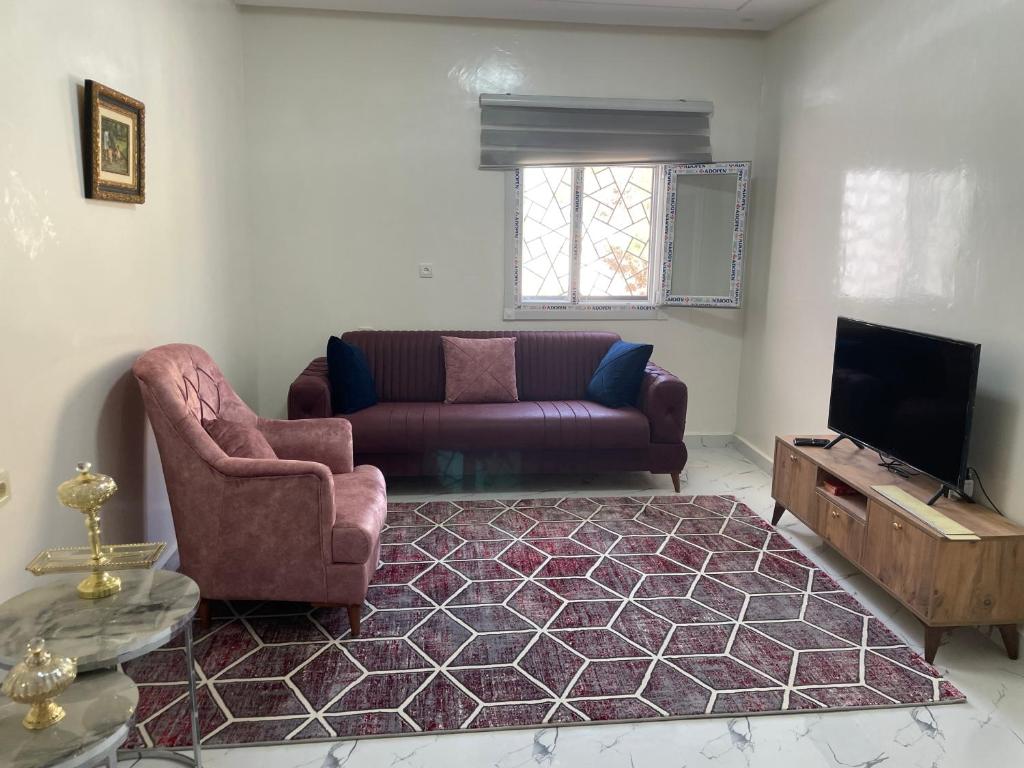 a living room with a couch and a tv at Luxury Qurtuba in Nouakchott