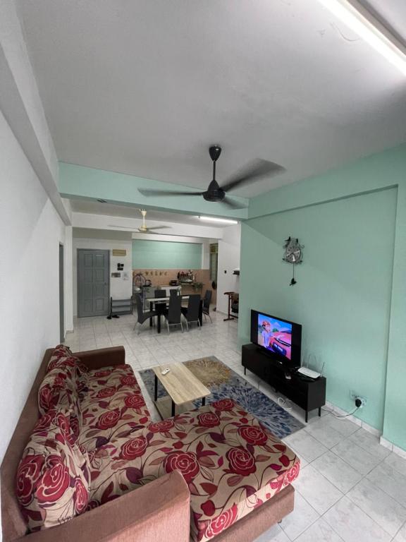 Blissful Breeze 4 ROOMS & NETFLIX by EZYROOM MELAKA في آير كيروه: غرفة معيشة مع أريكة وتلفزيون بشاشة مسطحة