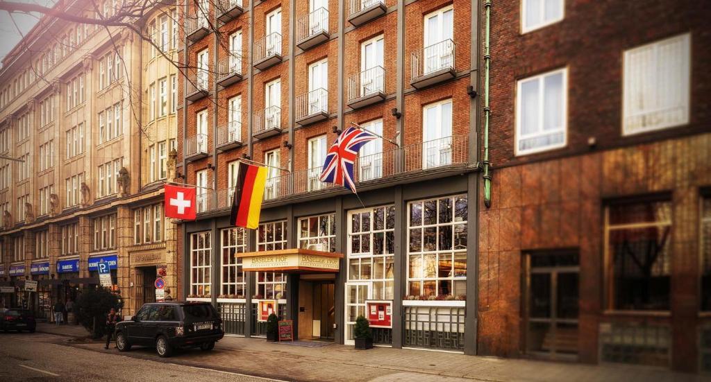 ein Gebäude mit Flaggen auf der Straßenseite in der Unterkunft Hotel Baseler Hof in Hamburg