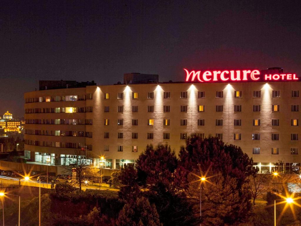 un hotel con un'insegna al neon sopra di esso di notte di Hotel Mercure Porto Gaia a Vila Nova de Gaia