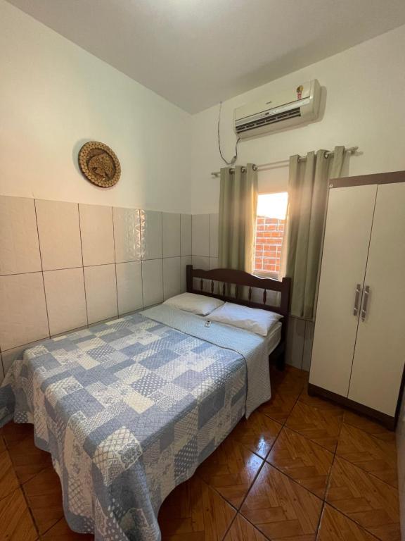 Habitación pequeña con cama y ventana en Casa Dona Vilma, en Barreirinhas