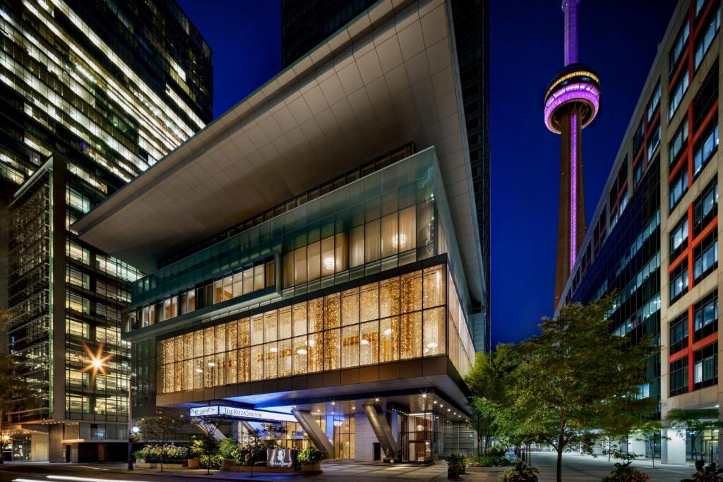 um edifício alto com a agulha espacial ao fundo em The Ritz-Carlton, Toronto em Toronto