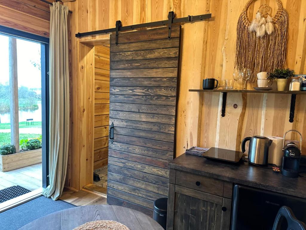 Cette chambre est dotée d'un mur en bois avec une porte coulissante. dans l'établissement Labieši, à Jurmala