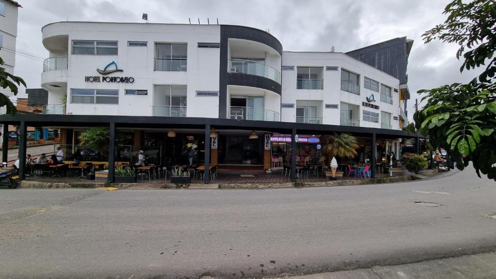 ein großes weißes Gebäude mit einem Restaurant auf der Straße in der Unterkunft Hotel Portobelo Guatape in Guatapé