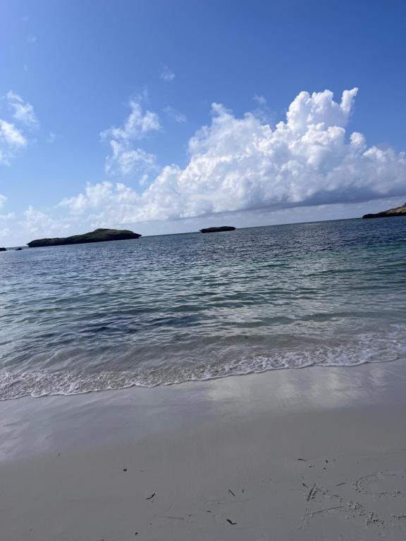 a beach with water and islands in the distance at Zuri home in Watamu