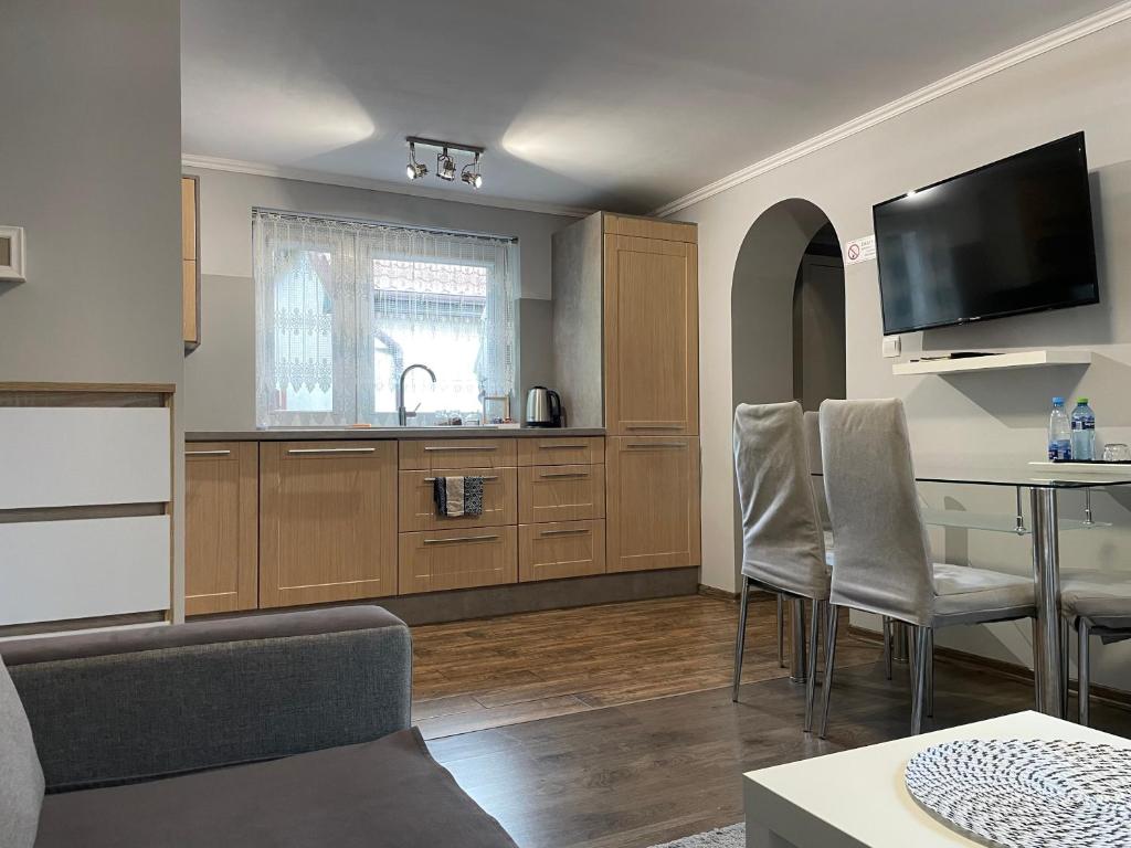 una cucina con armadi in legno e tavolo con sedie di Apartament Lazur a Piła