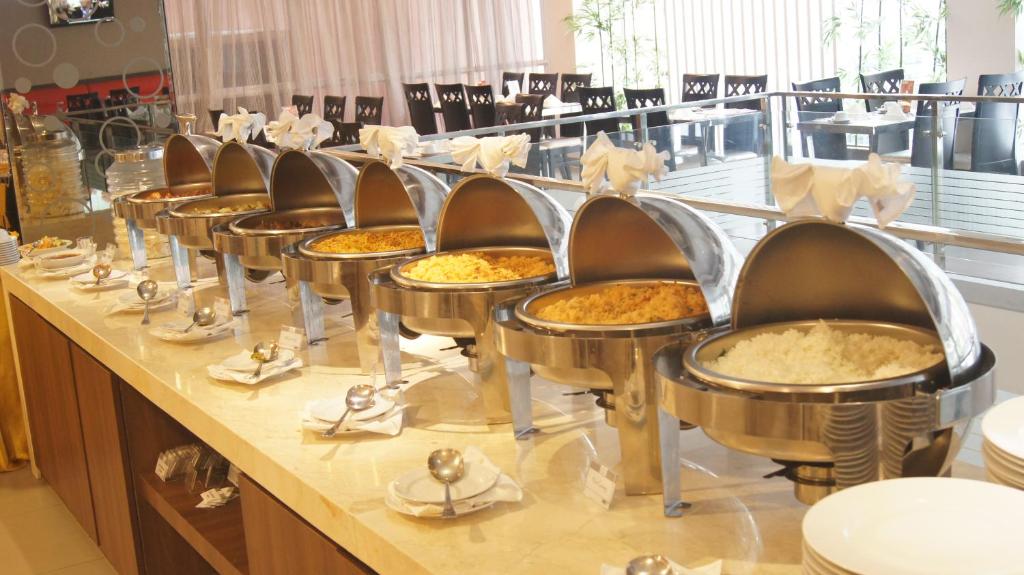 uma fila de cadeiras numa fila de buffet com tartes em Winstar Hotel em Pekanbaru