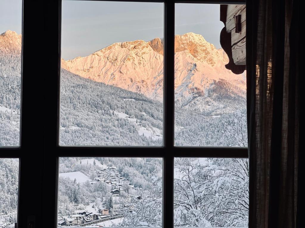 una ventana con vistas a una montaña nevada en Salzbergalm, en Berchtesgaden