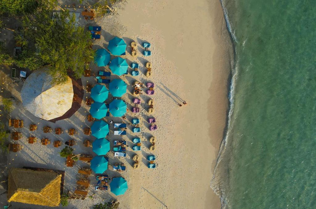 een uitzicht over een strand met stoelen en parasols bij Living Asia Sunset Resort in Gili Air