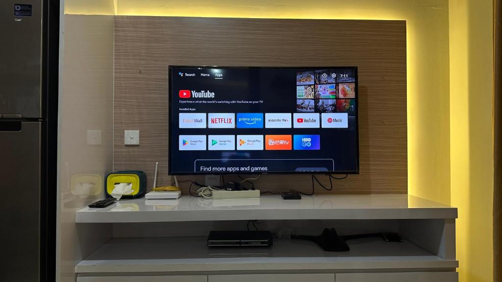 a flat screen tv sitting on top of a shelf at Apt Puri Orchard at puri in Jakarta