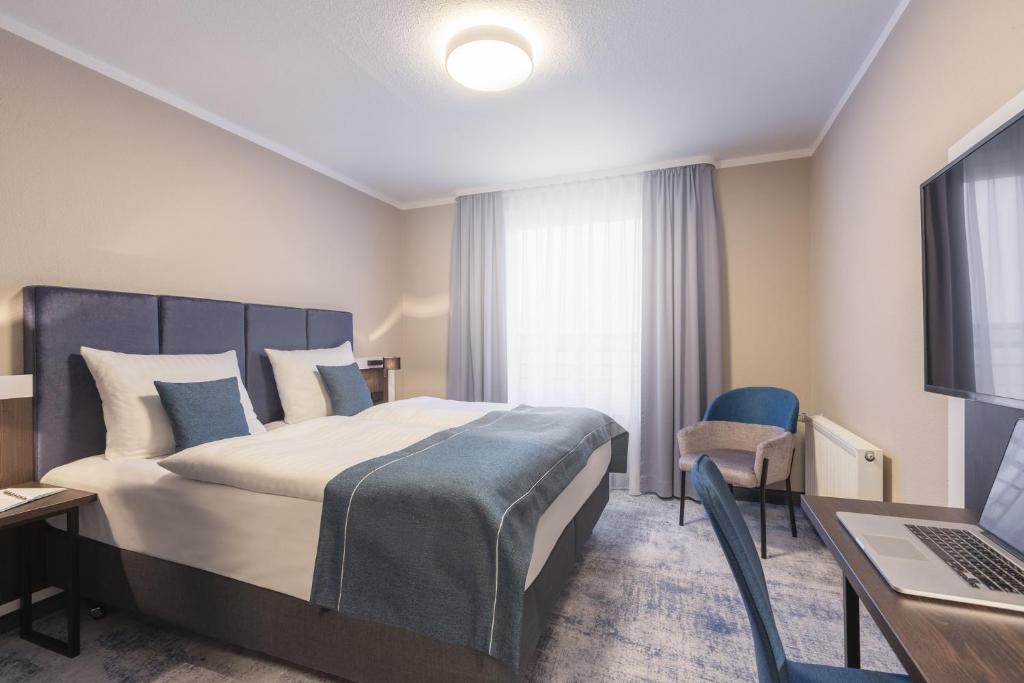 A bed or beds in a room at Garner Hotel Elmshorn, an IHG Hotel