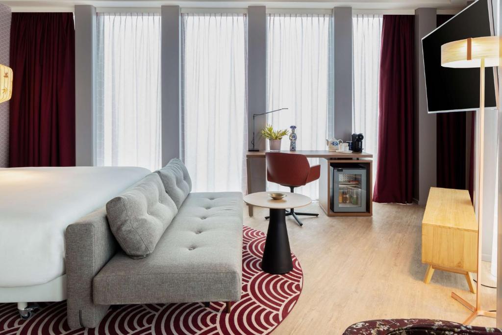 um quarto de hotel com uma cama e uma cadeira em nhow Amsterdam Rai em Amesterdão