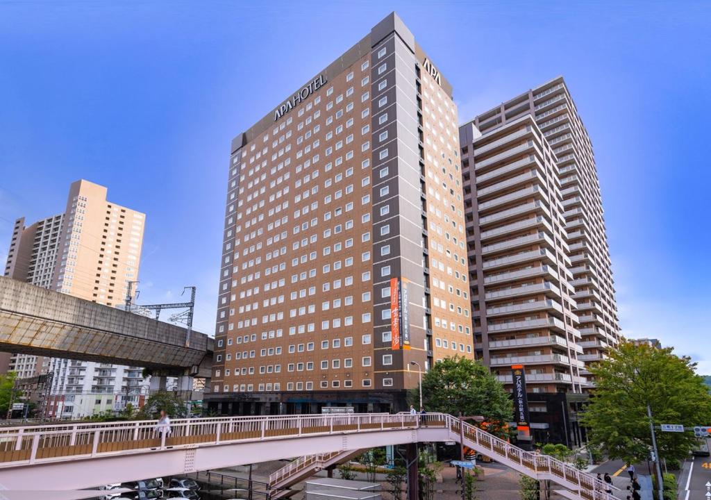 um edifício alto com uma ponte numa cidade em APA Hotel Sendai Eki Itsutsubashi em Sendai