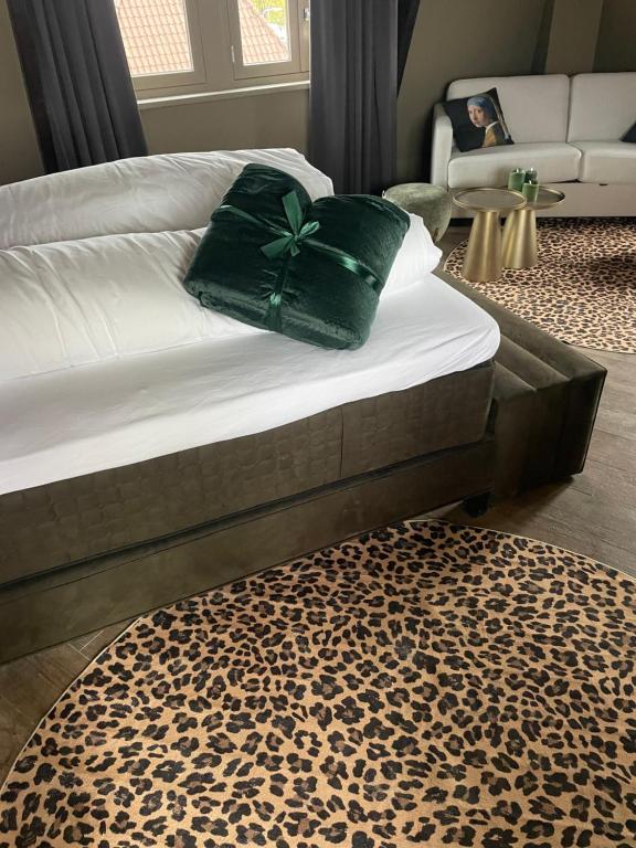 un letto con un fiocco verde sopra di esso di Boutique Hotel Noordeinde a Rijnsburg