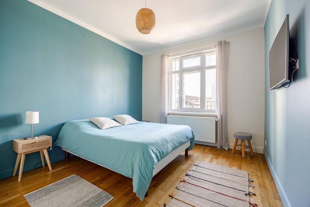 - une chambre bleue avec un lit et une fenêtre dans l'établissement Les chambres du Graoully - Le 109 - Metz Gare - Parking inclus - NO S-model, à Metz