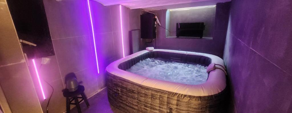 a bathroom with a tub with purple lights in it at My house jacuzzi Billiards in Brussels