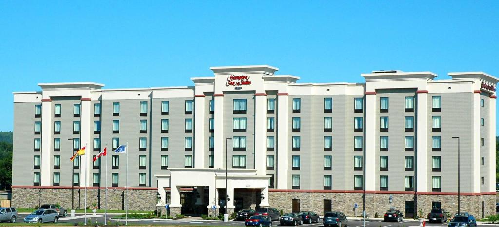 a large white building with cars parked in front of it at Hampton Inn & Suites by Hilton Moncton in Moncton