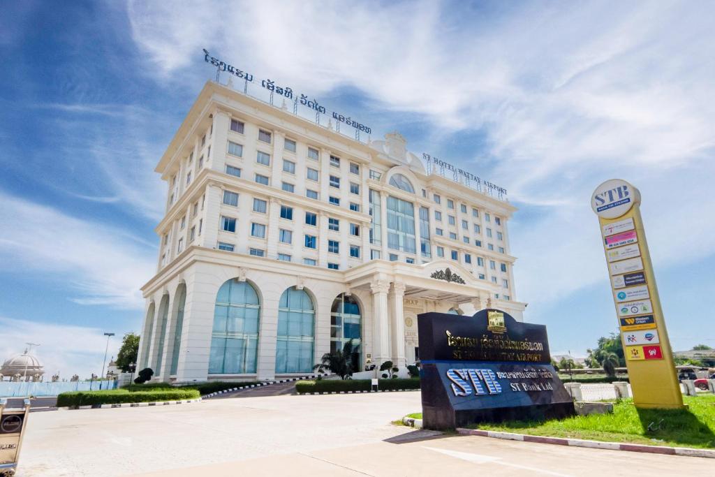 un gran edificio blanco con un cartel delante en ST Hotel Wattay Airport, en Vientiane