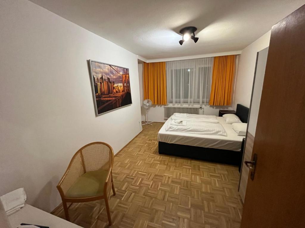 Cette chambre comprend un lit et une chaise. dans l'établissement City Appartement 4600, à Wels