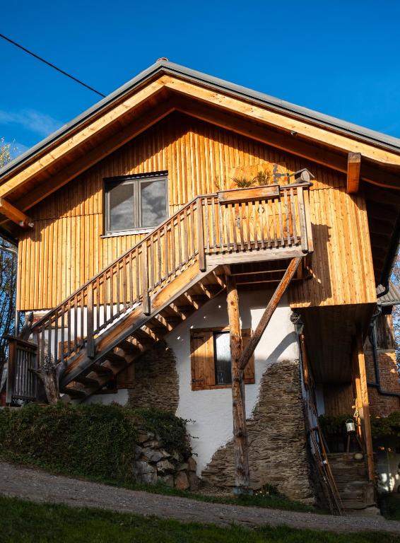 una casa di tronchi con un ponte sul lato di Schmiedlenz a Kumberg