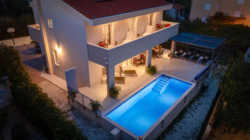 A piscina localizada em Villa Leonore in Omis with 4 en-suite bedrooms, heated pool, PS5, completely fenced yard & just 3min walk from sandy beach ou nos arredores