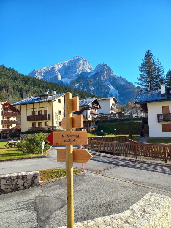 een straatbord met bergen op de achtergrond bij Appartamento Vale e Schena Cortina 4 posti letto in San Vito di Cadore