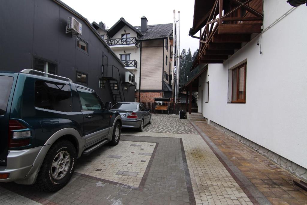 a black truck parked next to a white building at Proskurov Holiday Home in Bukovel