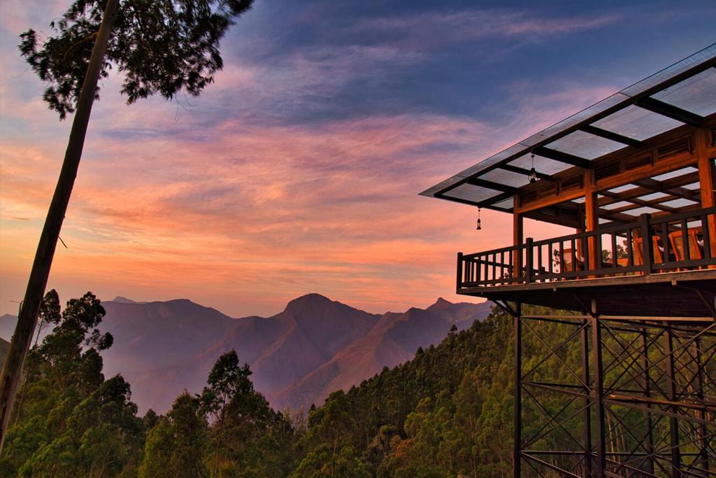 una vista dalla cima di una casa sull'albero al tramonto di Chandys Drizzle Drops - Munnar Top Station a Munnar