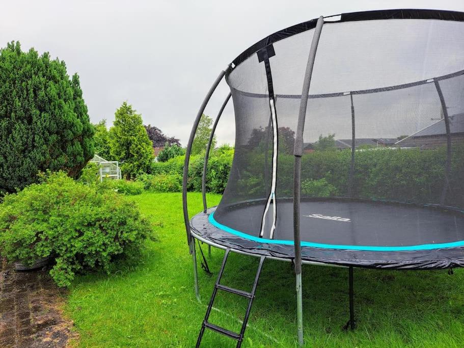 un trampolín vacío en el césped en un patio en Cozy villa, en Aarhus