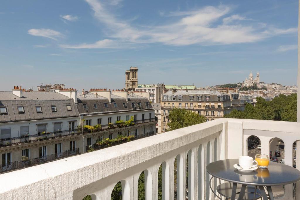 balcón con mesa y vistas a la ciudad en Libertel Gare Du Nord Suede, en París