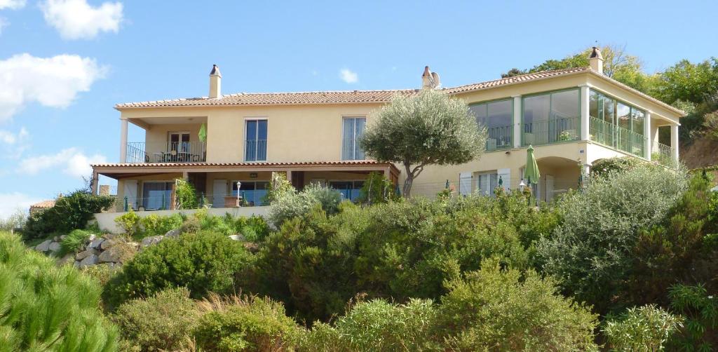 une maison au sommet d'une colline avec des arbres dans l'établissement Résidence Casa Régina, à Propriano