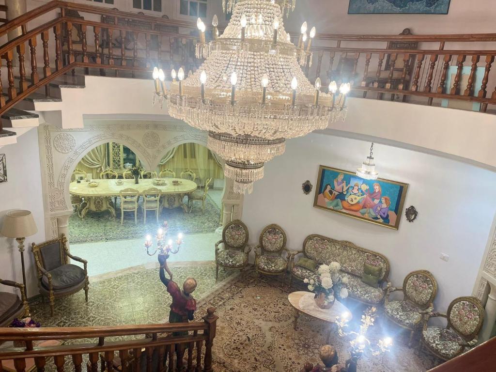 einen Blick über ein Wohnzimmer mit einem Kronleuchter in der Unterkunft Dar Henani in Monastir