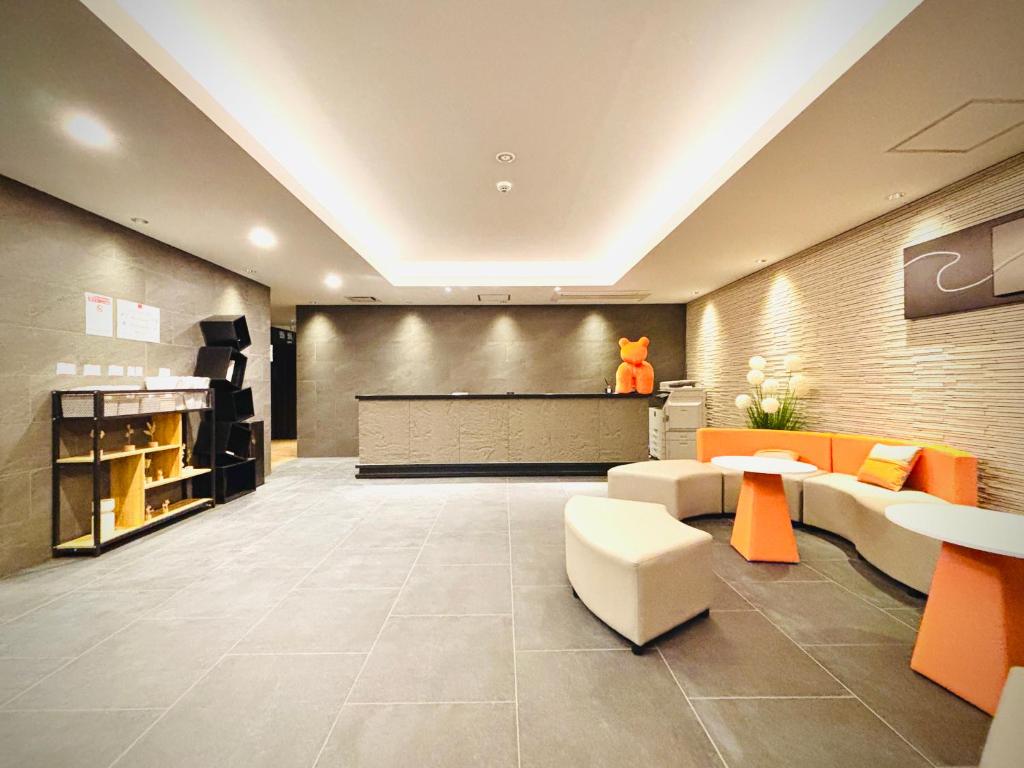 - un hall avec un mobilier orange et blanc et un piano dans l'établissement 嵐 Hotel Arashi 難波南店 Nambaminami, à Osaka