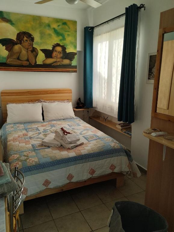 1 dormitorio con 1 cama y una pintura en la pared en Sweet Home, en Egio