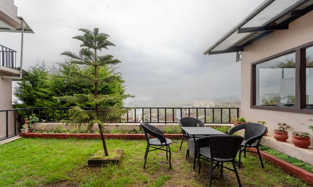 a patio with chairs and a table and a tree at Treebo Tranquil Heights in Kodaikānāl