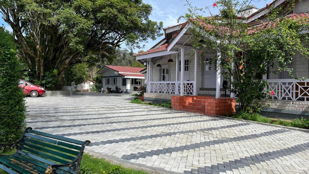 a green bench sitting in front of a house at Bruton resorts in Kodaikānāl