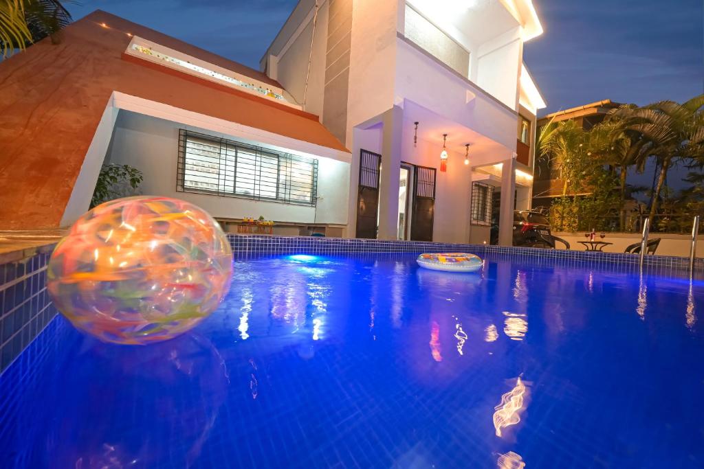 uma piscina com uma bola em frente a uma casa em ll EMPYREAN STAY ll WHITE UNICORN VILLA ll 3BHK ll AC ll PRIVATE BIG POOL ll LUXURY em Lonavala