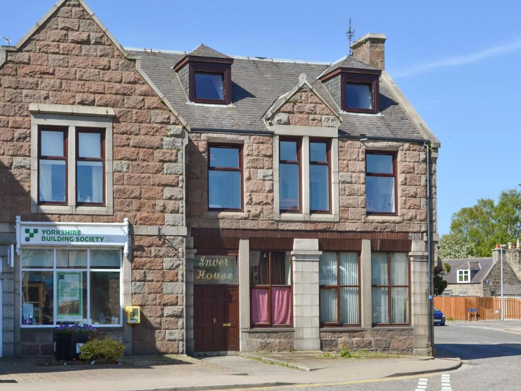 un vieux bâtiment en briques au coin d'une rue dans l'établissement Inver House Apartment, à Inverurie