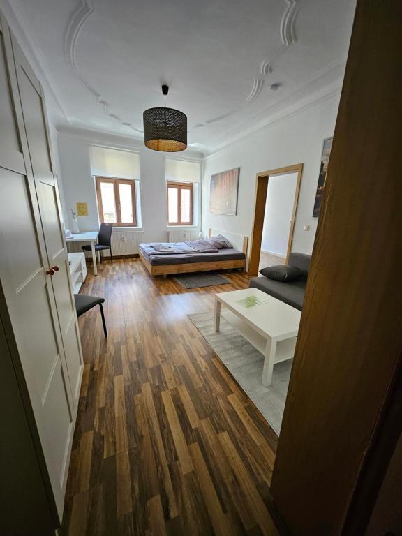 un soggiorno con letto e tavolo di FERIENWOHNUNG APARTMENT in ZITTAUER STADTZENTRUM INNENSTADT INNENRING TOP LAGE - WOHNEN AUF ZEIT IN ZITTAU - 1 RAUM WOHNUNG a Zittau