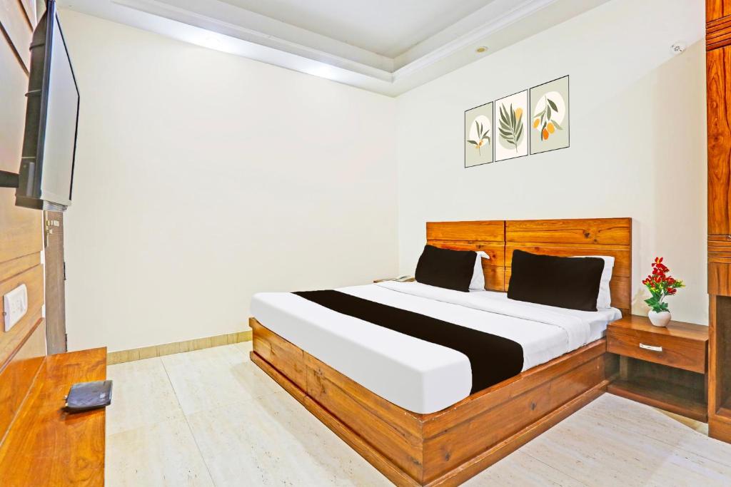 Super Hotel O Gurgaon Old Town formerly Prince Inn في جورجاون: غرفة نوم بسرير وتلفزيون