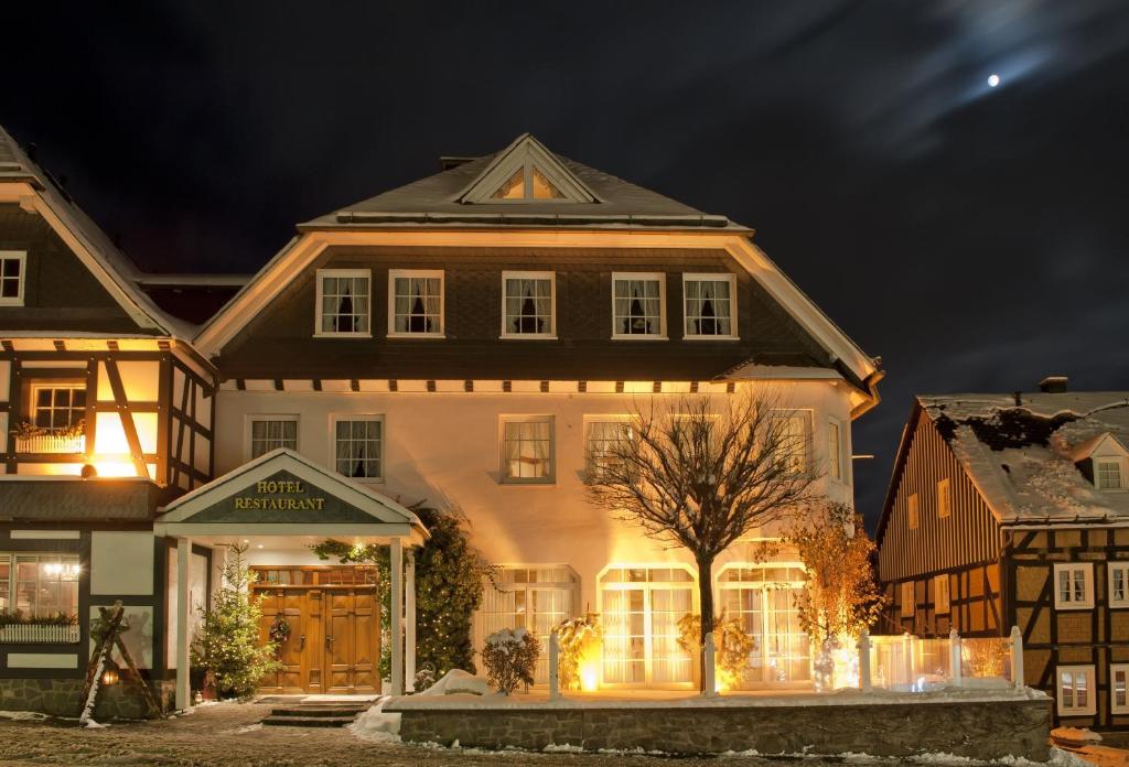 een groot huis met lichten ervoor bij Hotel Sauerländer Hof in Hallenberg