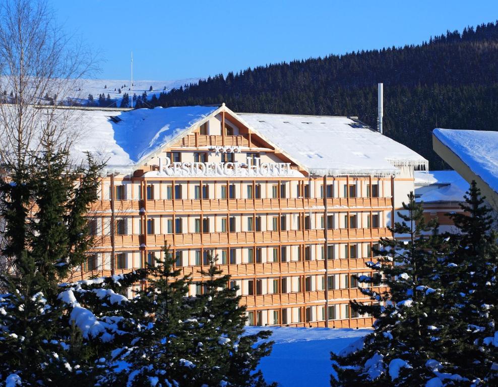 un grand bâtiment avec de la neige au-dessus dans l'établissement Residence Hotel, à Donovaly