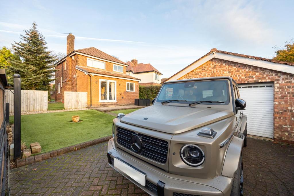 Manchester Luxury Home - Hale Barns في هييل: شاحنة فضية متوقفة في ممر أمام منزل