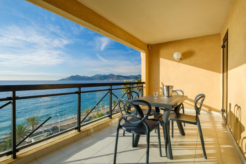 d'un balcon avec une table et des chaises et une vue sur l'océan. dans l'établissement Residhotel Villa Maupassant, à Cannes