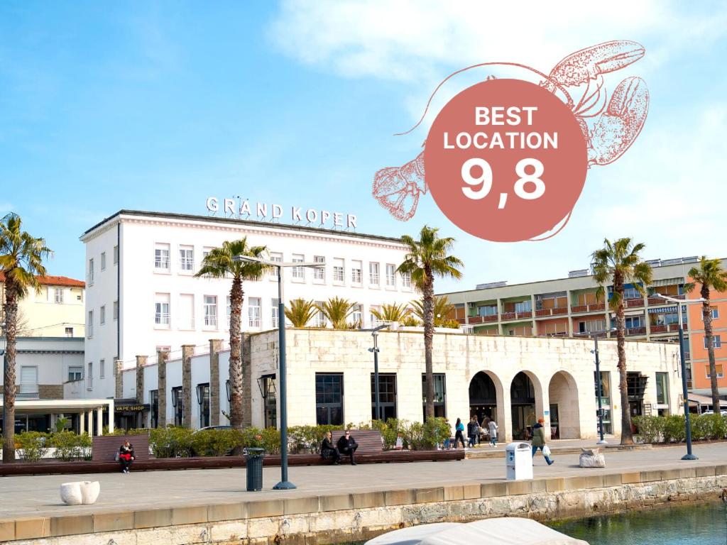 a large white building with a sign that reads best vacation at Hotel Grand Koper in Koper