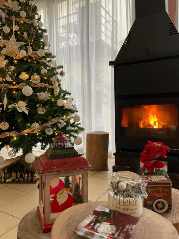 a christmas tree in a living room with a fireplace at Corinthian Village in Vrahati